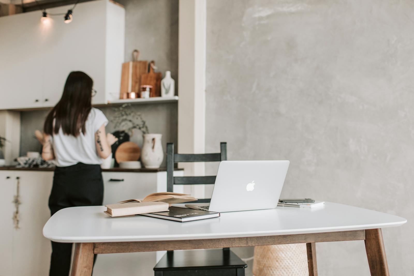 Woman Standing Near The Kitchen Counter With Her Laptop Open On Table