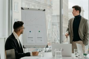 Man in Black Suit Jacket Writing on White Board