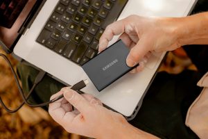 A person using a laptop computer with a mouse