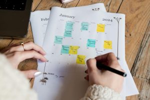 Woman Hand with Pen over Calendar
